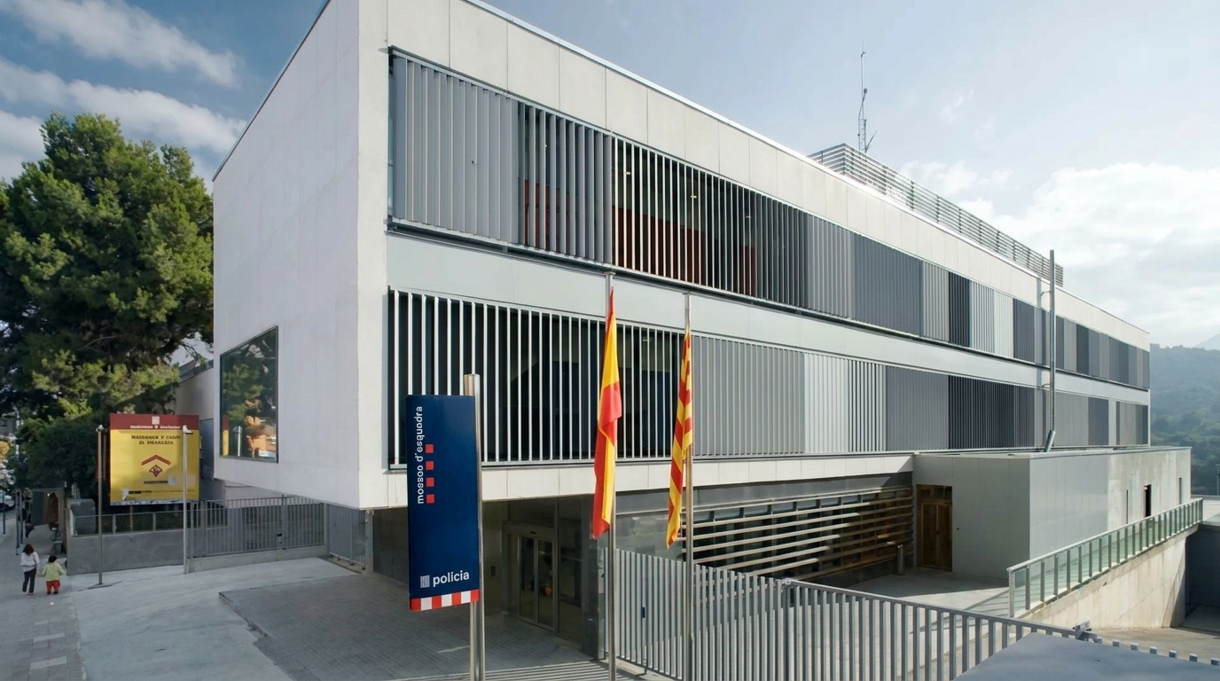 Современное здание полиции Mossos d'Esquadra Современное здание полиции Mossos d'Esquadra с вертикальными фасадными ламелями и флагами у входа