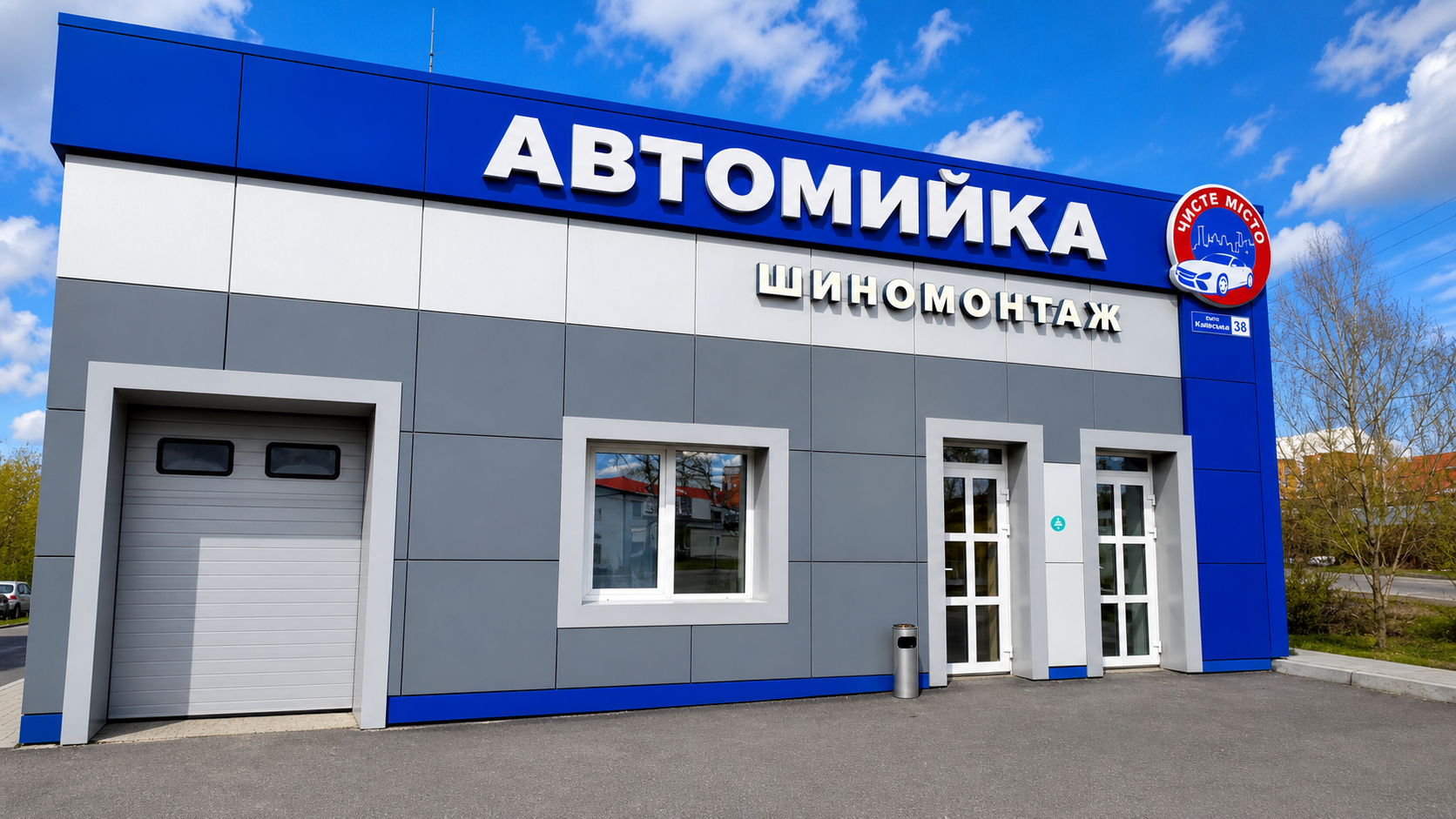 Автомойка и шиномонтаж Фасад автомойки и шиномонтажа с сине-серой отделкой и крупной вывеской «Автомийка»